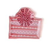 a pink christmas accent plate in the shape of a christmas gift. 