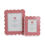 Two pink scalloped photo frames on a white background