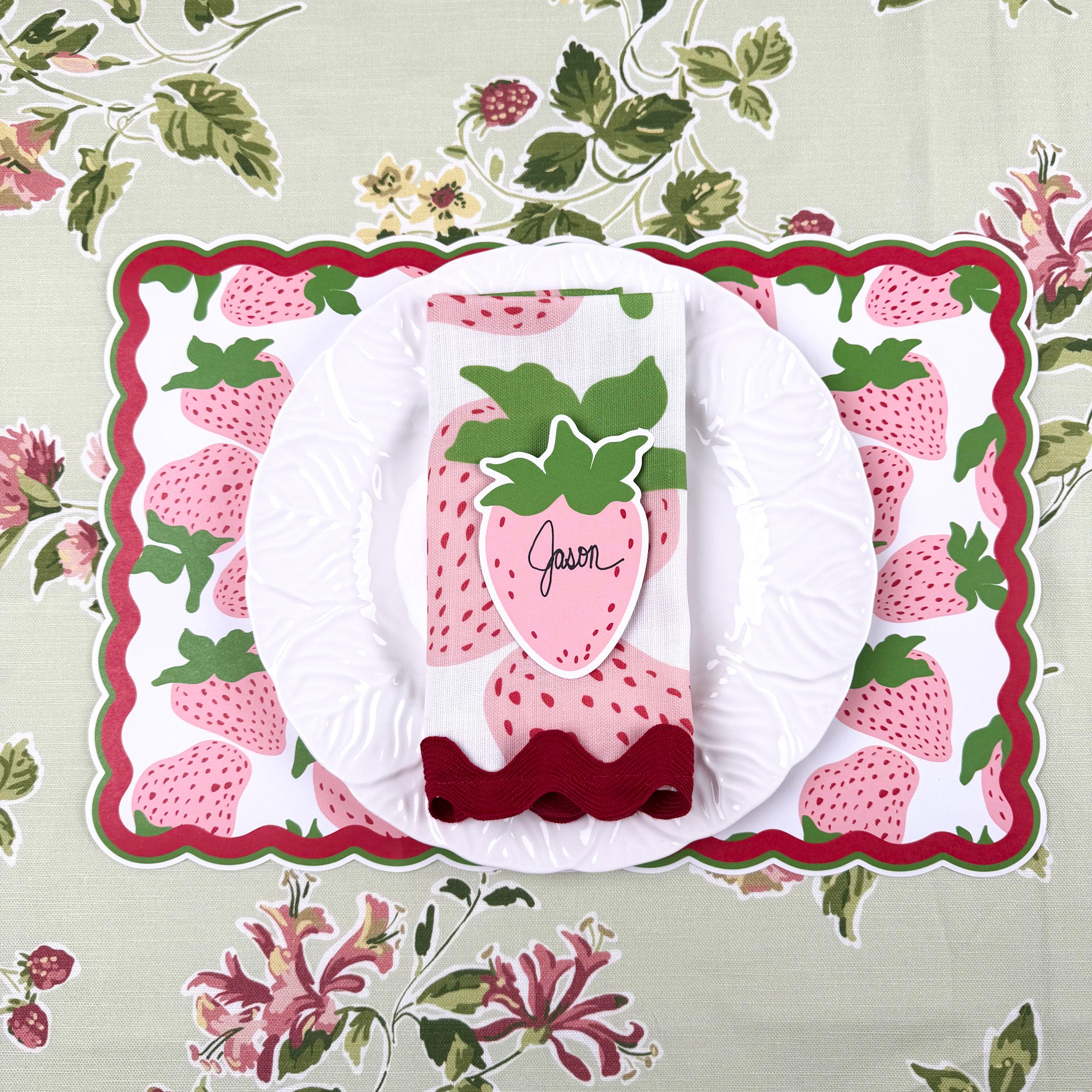 strawberry paper placemat spring table setting with white plate and strawberry napkin.