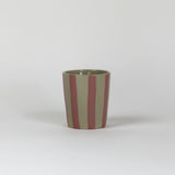 A pink striped ceramic cup in on a white background. 