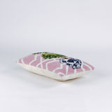 side of a Rectangular decorative pillow with a pink and white lattice background featuring a green double topiary plant in a blue and white chinoiserie-style pot.