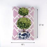 Pink rectangular pillow with a double topiary design in a blue and white pot shown with 18 inch length and 12 inch width.