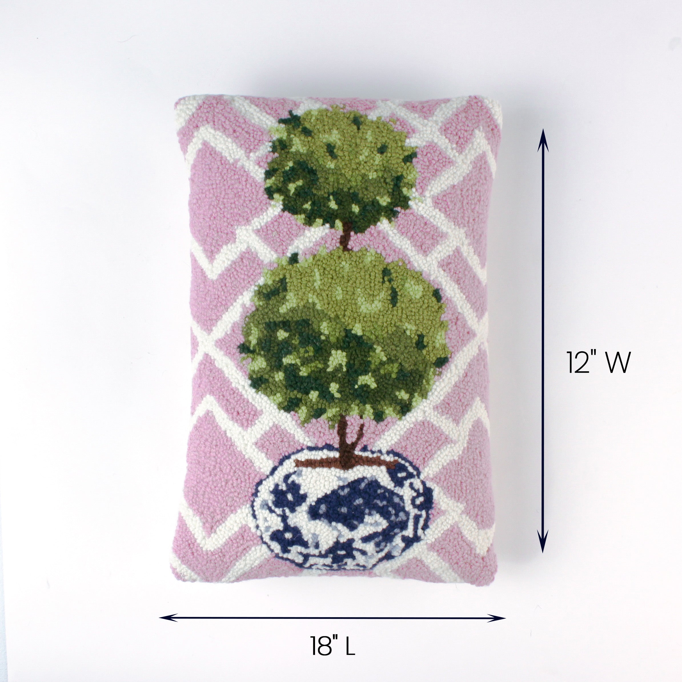 Pink rectangular pillow with a double topiary design in a blue and white pot shown with 18 inch length and 12 inch width.