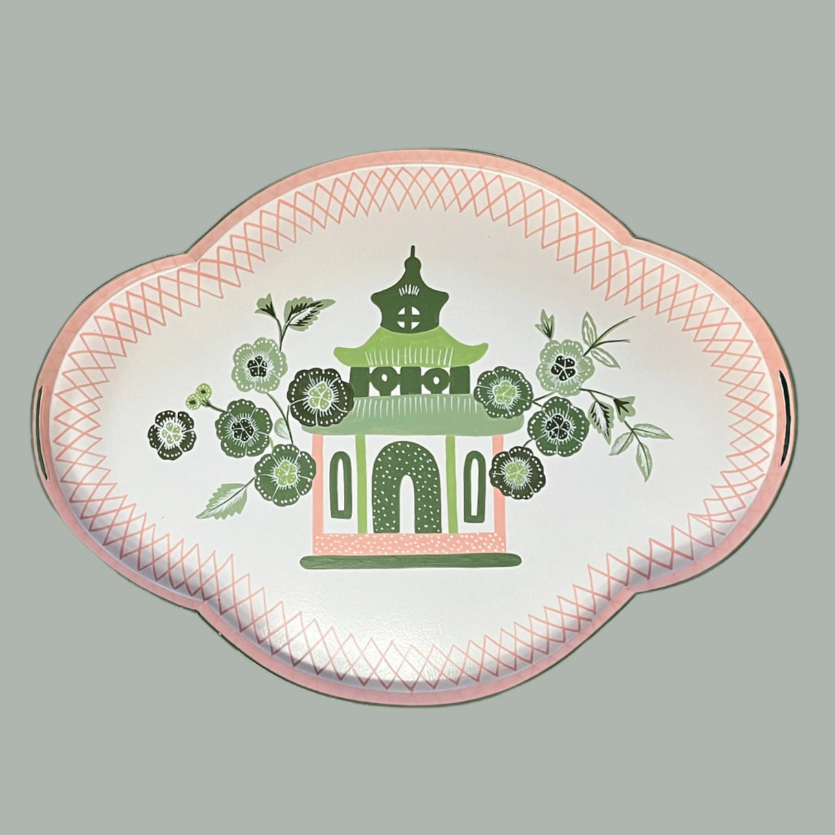 A pink and green metal tray featuring a central pagoda motif surrounded by blossoms. 