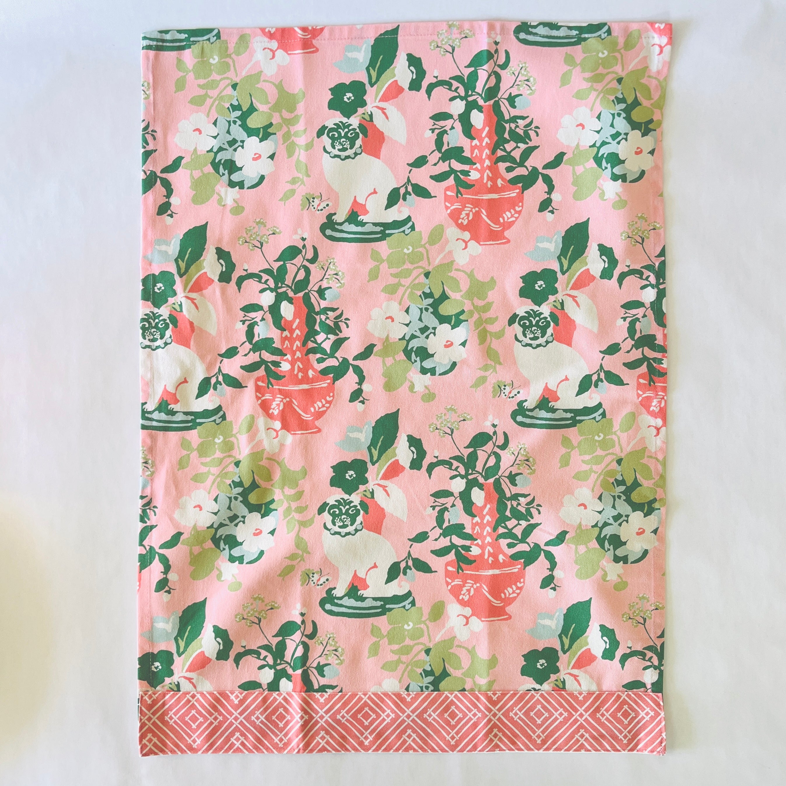 a pink chinoiserie tea towel from madcap cottage with pug and vase motifs.