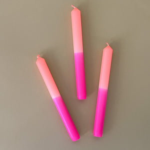 three pink and orange taper candles 