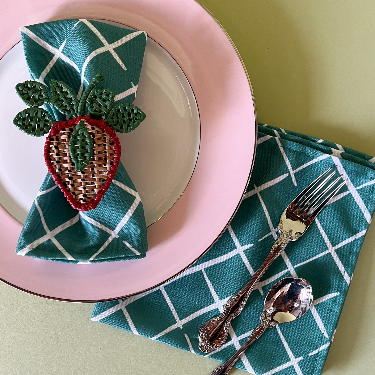 bahama court green dinner napkins from madcap cottage resting on a pink dinner plate