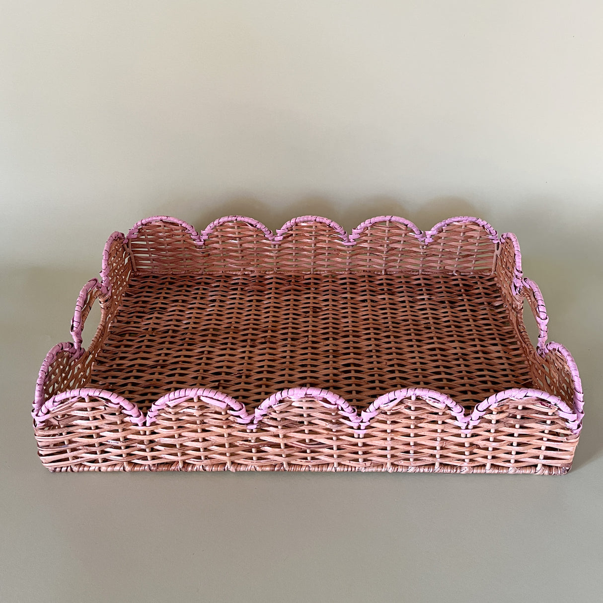 rattan serving tray with pink scalloped accent