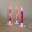 pink marbled taper candles in white ceramic candle holders