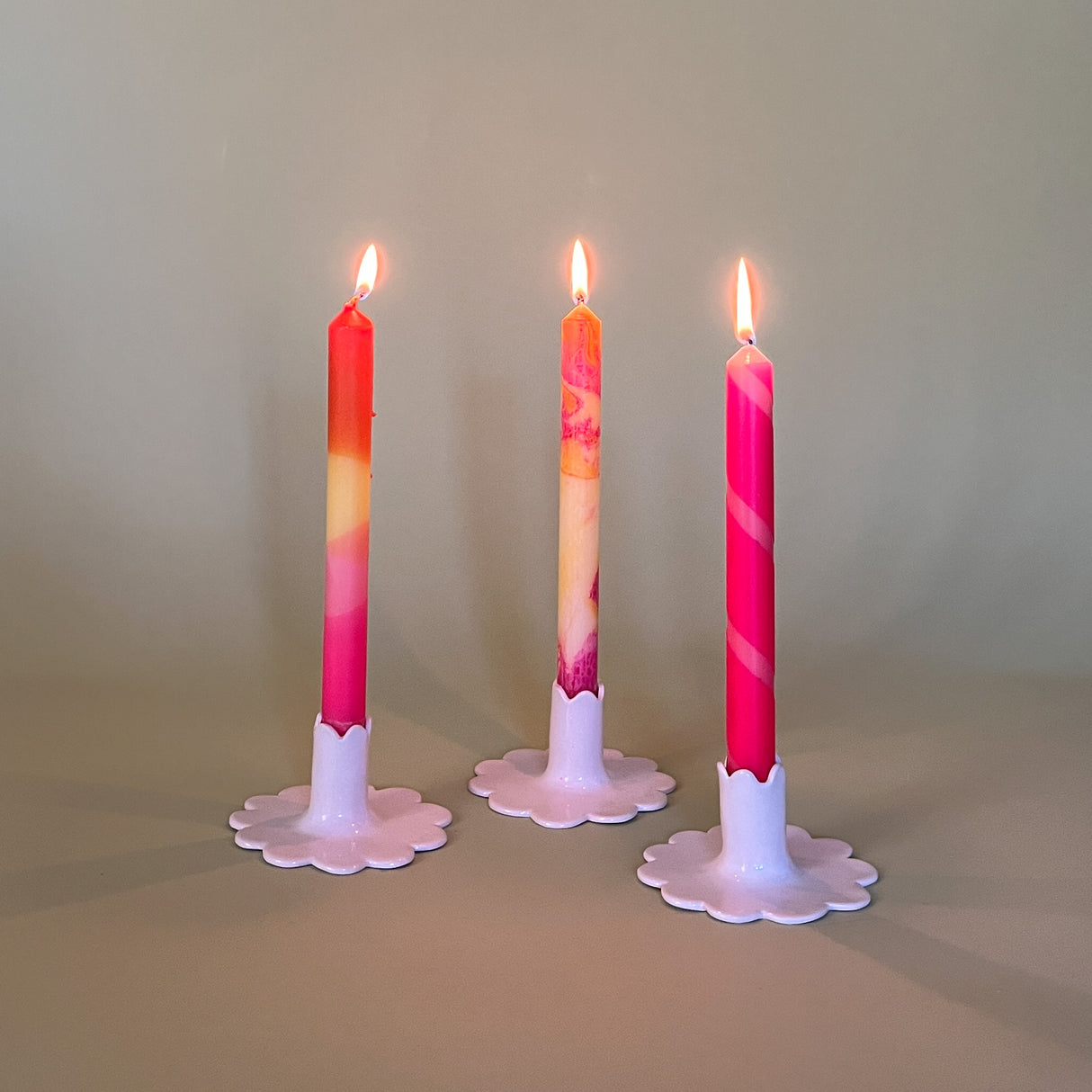 pink marbled taper candles in white ceramic candle holders