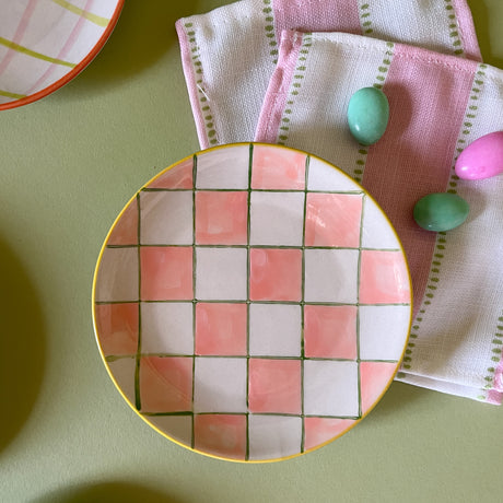 pink and white checkered ceramic plate with cocktail napkins and candy