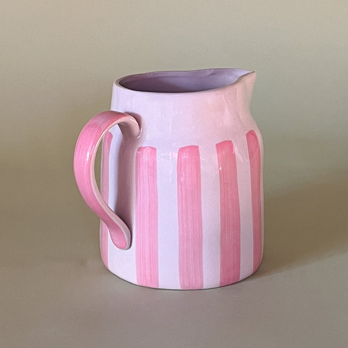 pink and white striped ceramic pitcher handle view