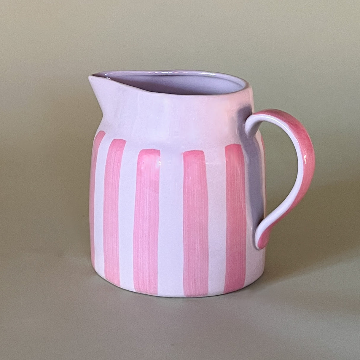 pink and white striped ceramic pitcher side view