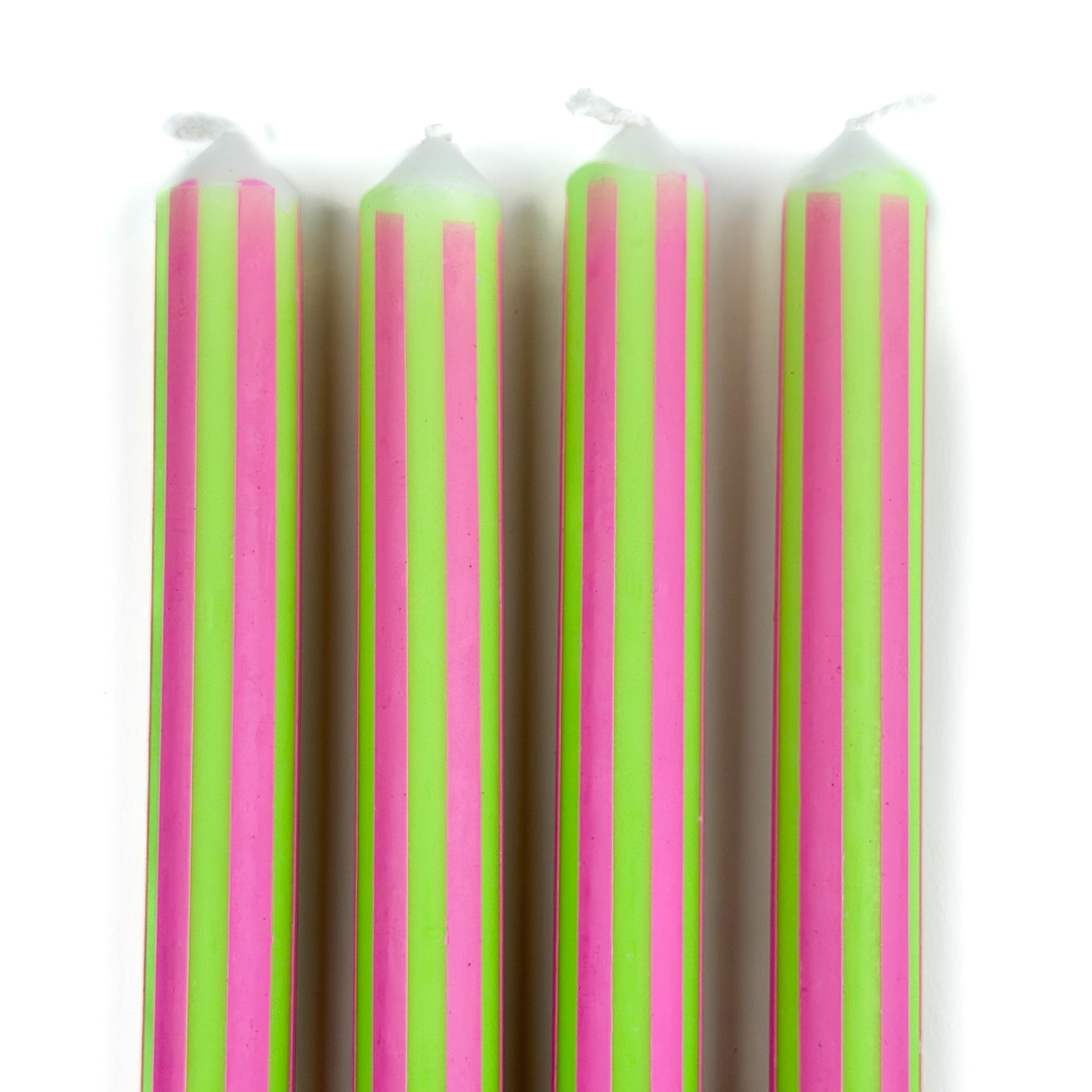 Green and pink pinstripe taper candles set with colorful vertical stripes for spring table decor.