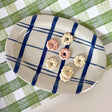 An oval shaped ceramic blue and white platter featuring a blue plaid pattern on white background. 