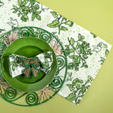 a springtime strawberry print fabric easter table runners in green with a green plate and round rattan charger
