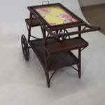 A brown vintage bar cart with a removable yellow floral tray