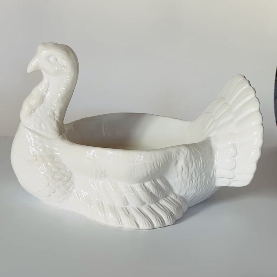 a video of a white ceramic turkey centerpiece shown in different angles and positions