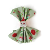 a green christmas napkins with pugs, christmas trees and candy cane motifs inside a santa napkin on a white background