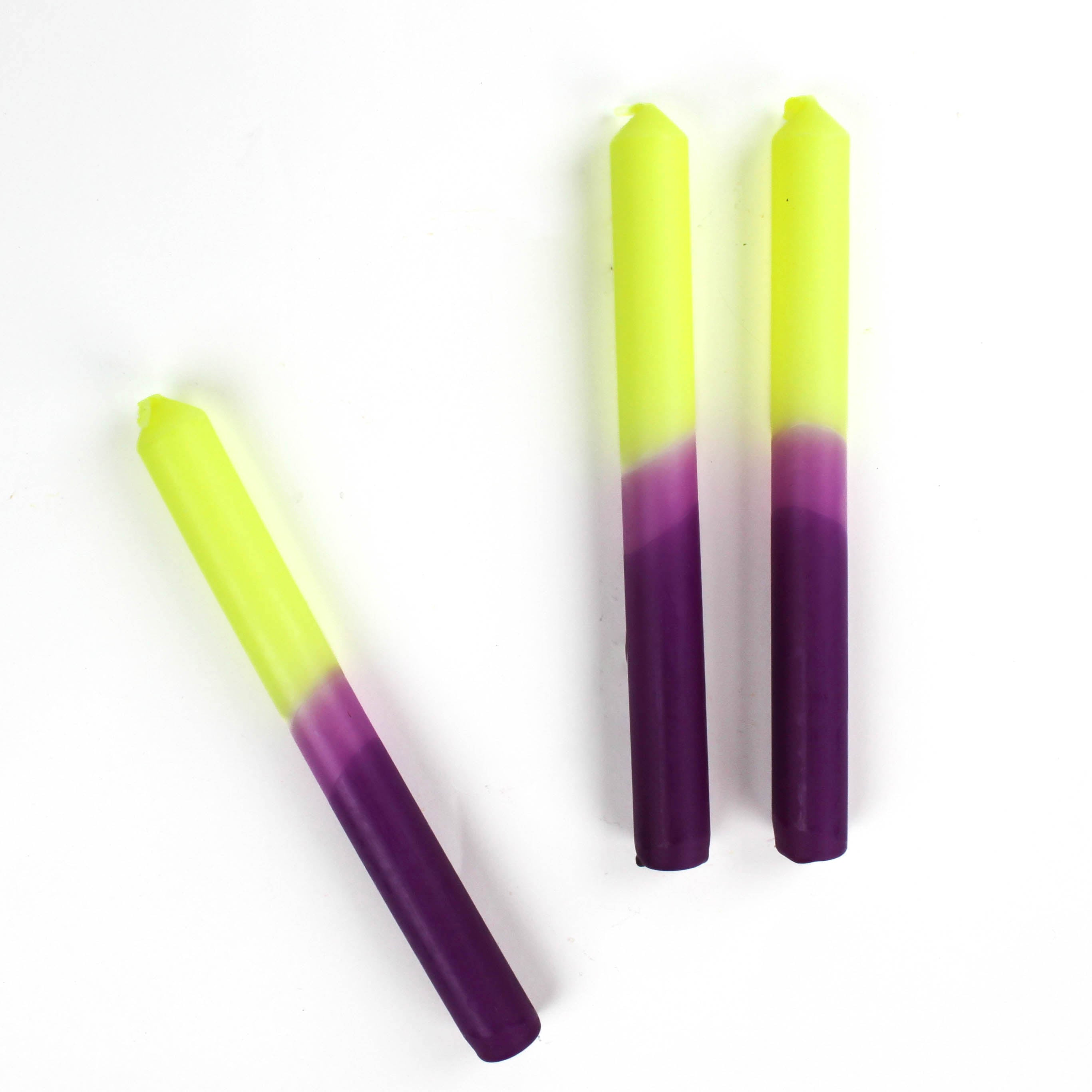 Three taper candles with a purple and yellow gradient