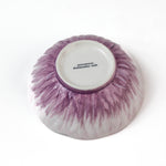 bottom view of a purple flower shaped bowl on a white background