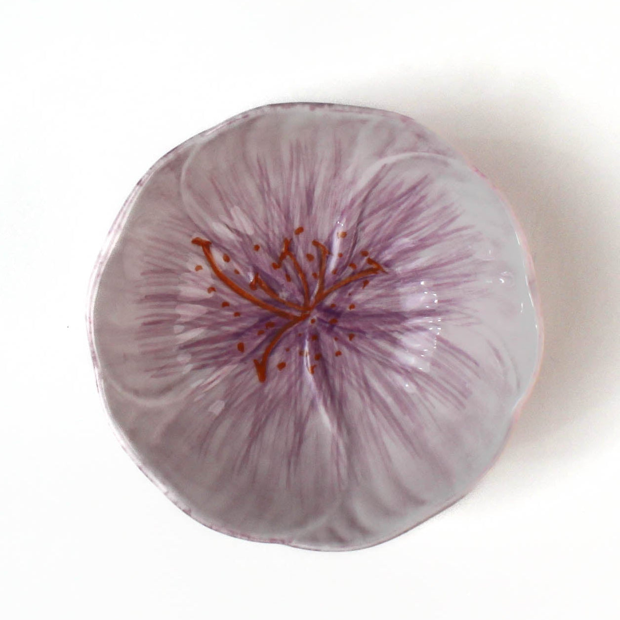 top view of a purple flower shaped bowl on a white background