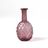 Pink glass vase with textured surface on a white background