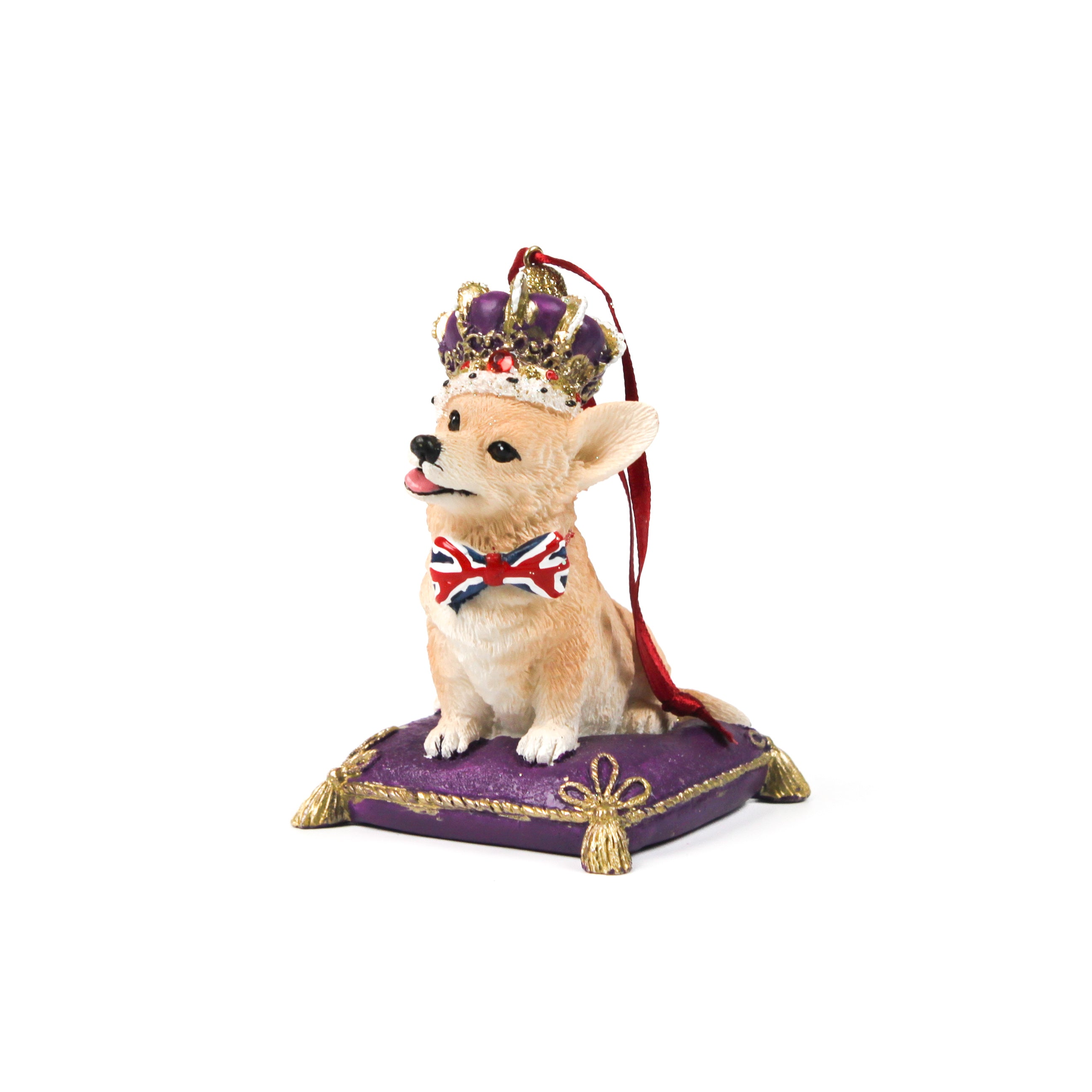 corgi christmas ornament with a crown and Union Jack bow tie on a purple cushion.