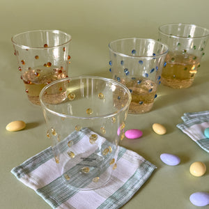 three-dimensional drinking glasses with colored raised dots on cocktail napkin