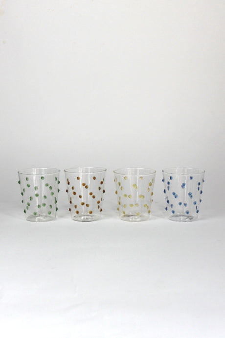 four glasses with raised dot embellishments, one green, one brown, one yellow and one blue