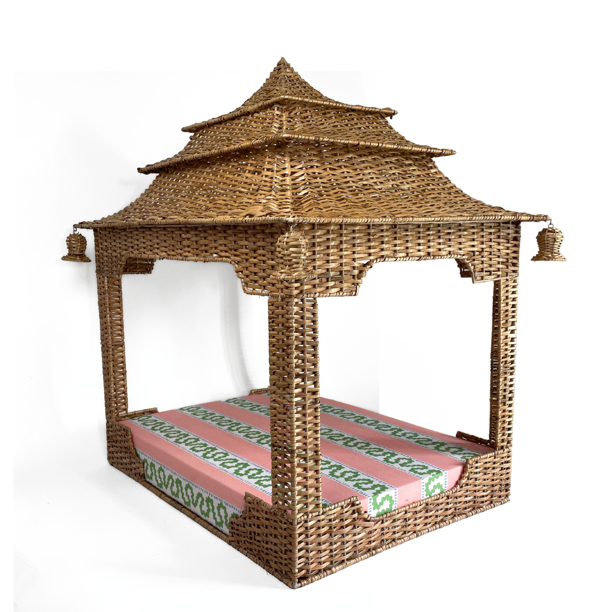 a rattan pagoda dog bed with a green pink and white striped mattress from madcap cottage