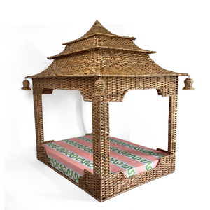 a rattan pagoda dog bed with a green pink and white striped mattress from madcap cottage