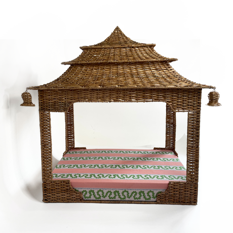 a rattan pagoda dog bed with a green pink and white striped mattress from madcap cottage