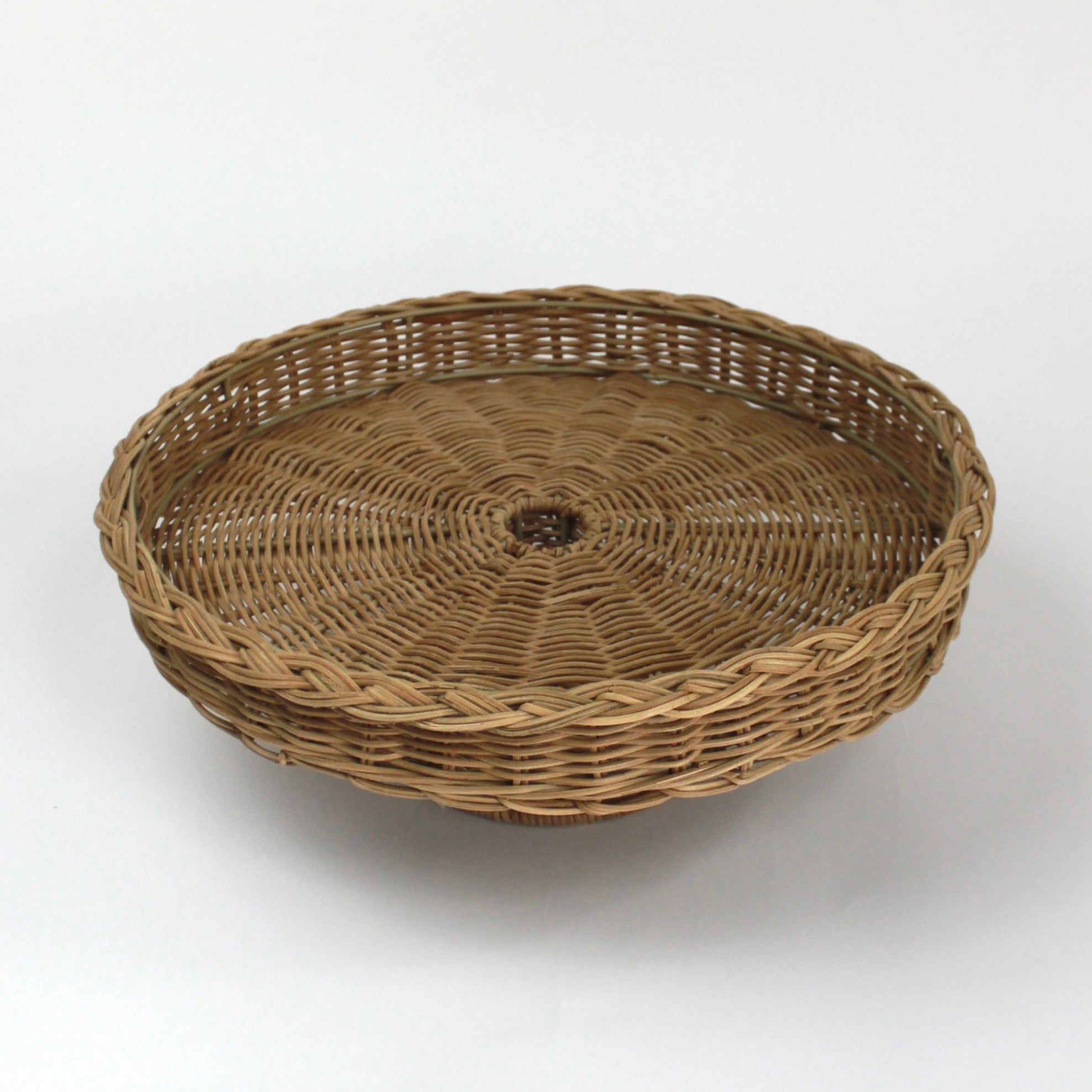 A brown rattan pedestal bowl from madcap cottage
