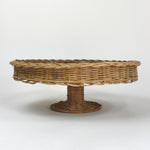 A brown rattan pedestal bowl from madcap cottage