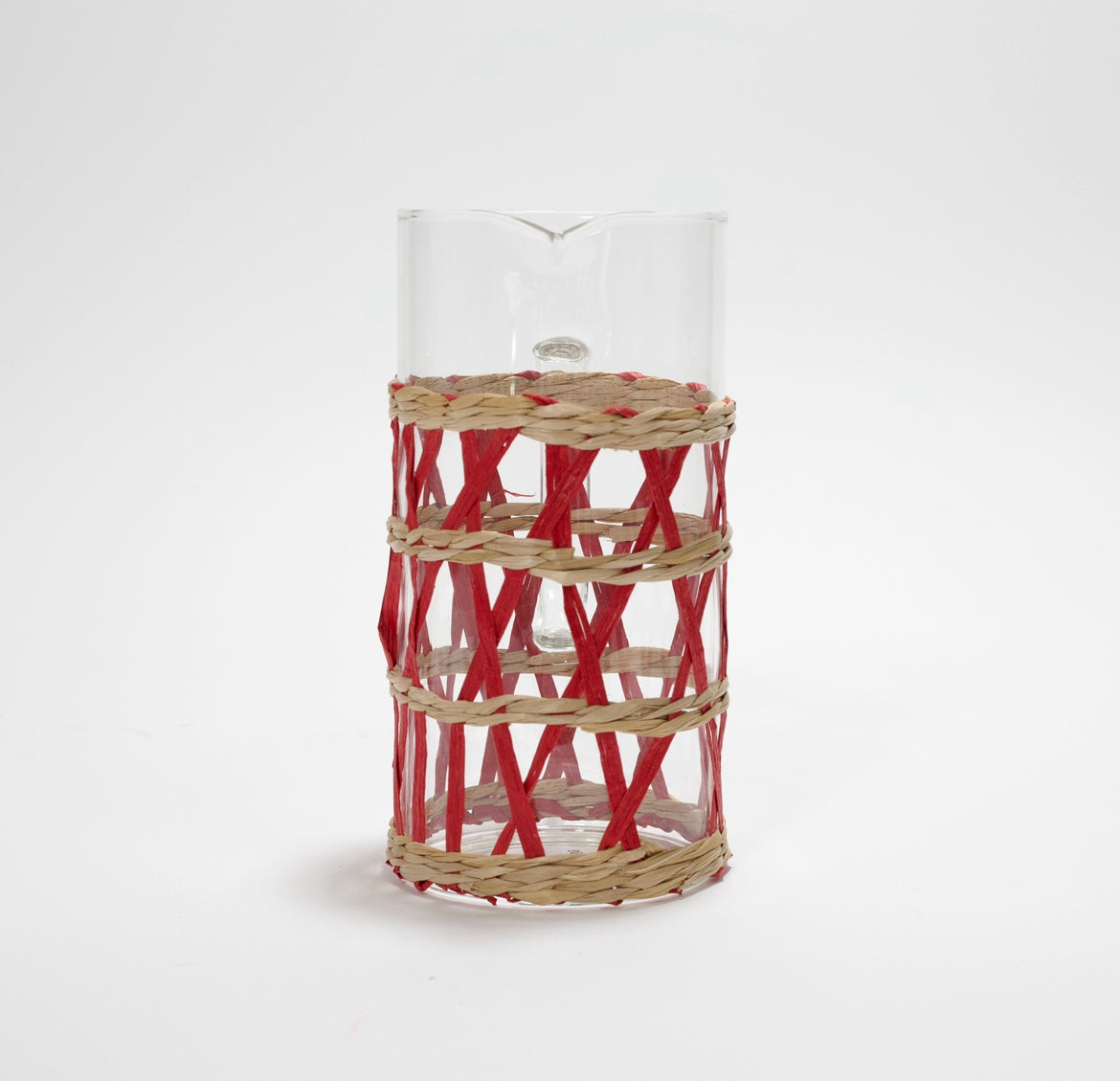 a glass pitcher wrapped in red and beige rattan