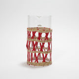 a glass pitcher wrapped in red and beige rattan