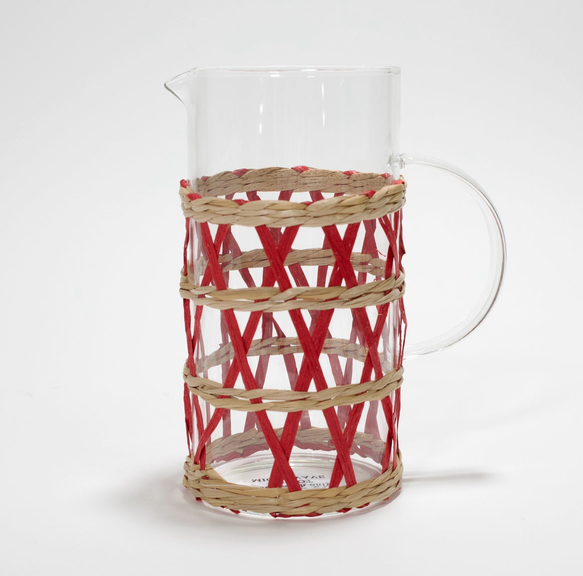 a glass pitcher wrapped in red and beige rattan