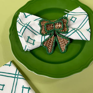 green rattan bow napkin ring on napkin on green plate