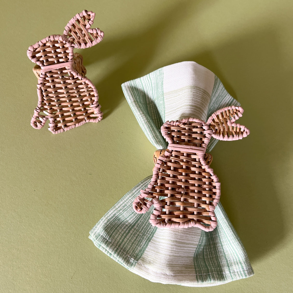 rattan bunny napkin ring pair with one on a green gingham napkin