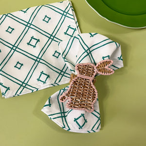 rattan bunny napkin ring on a green and white dinner napkin