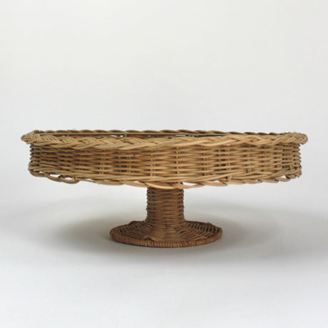 A brown rattan pedestal bowl from madcap cottage