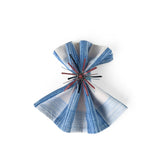 Red Starburst patriotic napkin ring displayed on a blue striped cloth napkin.