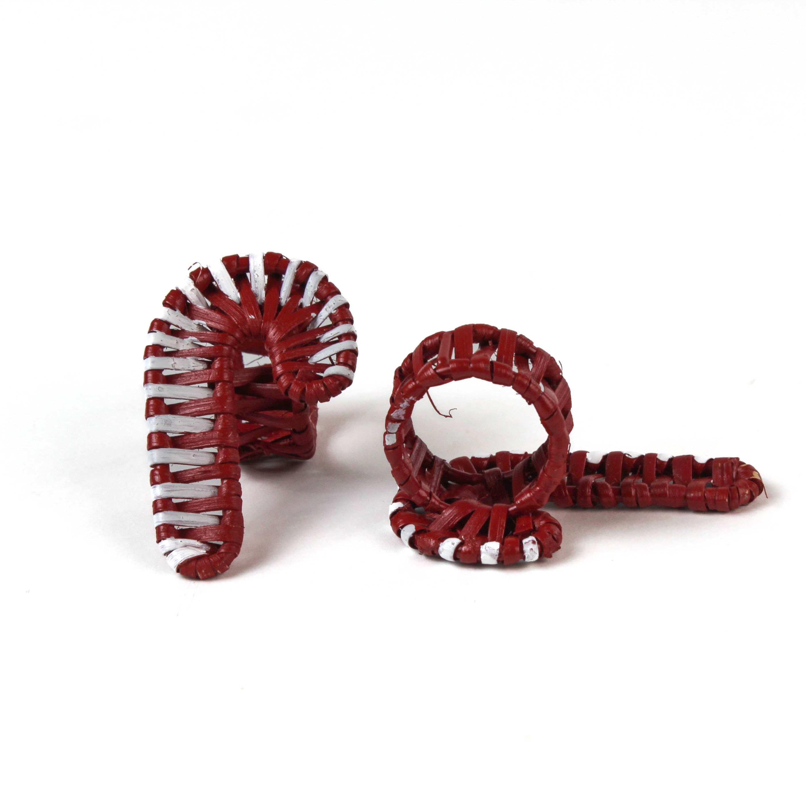 two rattan white and red candy cane christmas napkin rings against a white backgroud. 