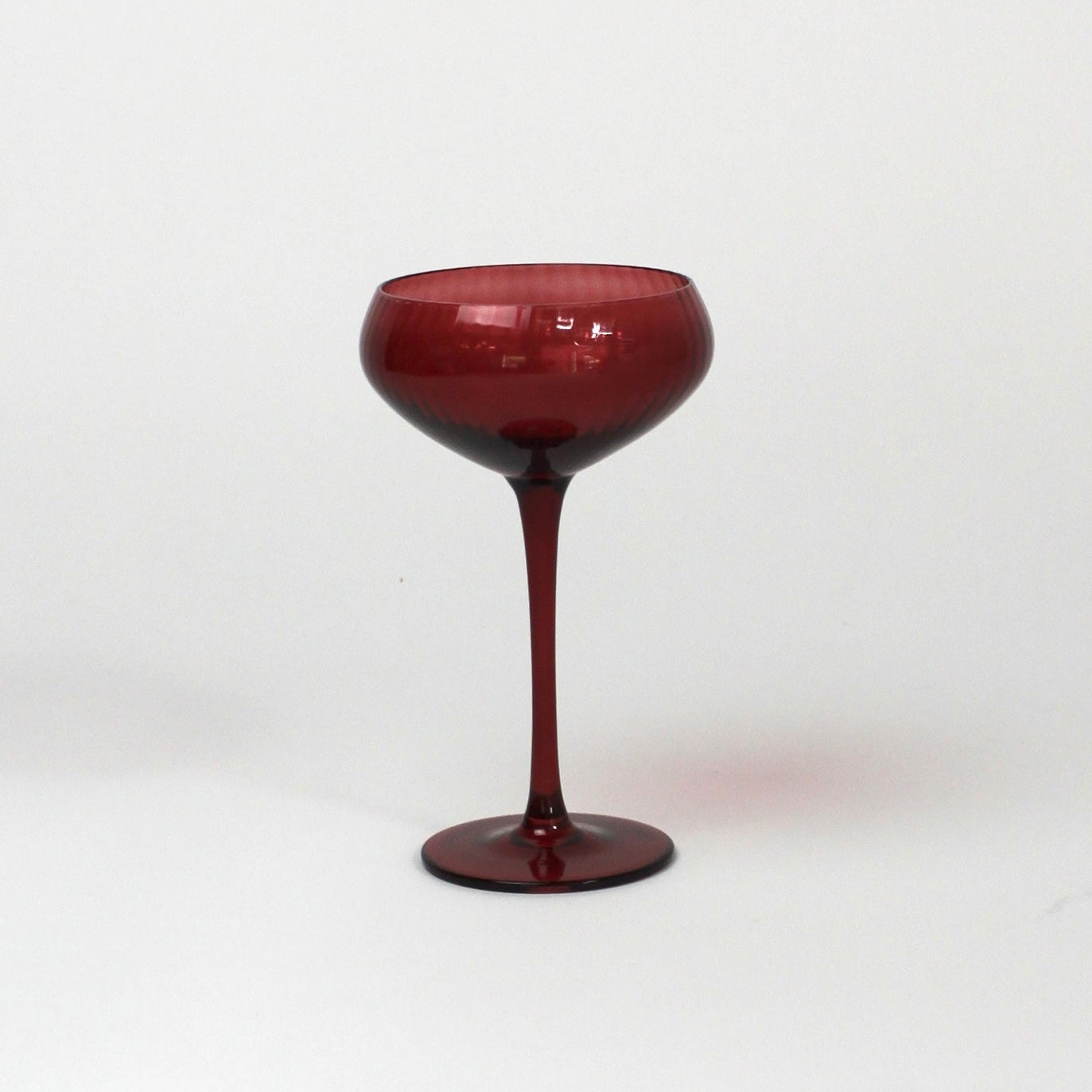 a red coupe glass from madcap cottage o a white background