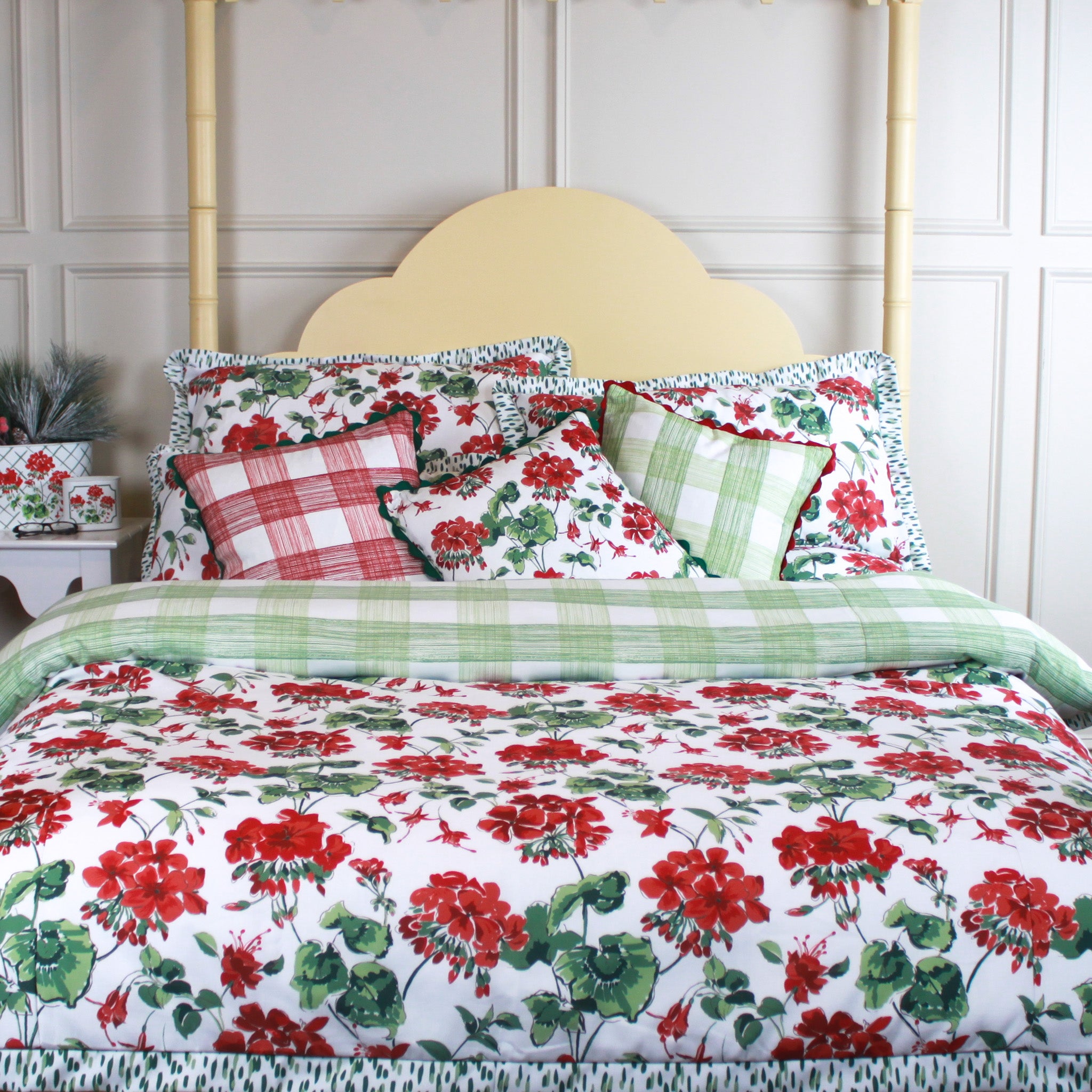 Floral and plaid patterned bedding set on a bed with a white wall background