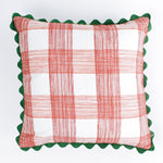 Square decorative pillow with a red gingham plaid pattern on a white background, accented with a dark green scalloped trim around the edges.