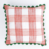 Square decorative pillow with a red gingham plaid pattern on a white background, accented with a dark green scalloped trim around the edges.