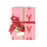 a Pink wrapping paper roll with a festive pattern featuring lobsters, bows, and decorative stripes.