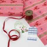Pink wrapping paper featuring a blue ribbon and orange lobster motif